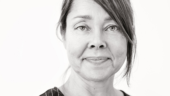Svartvit porträttbild på Tatja Hirvikoski med vit bakgrund.
