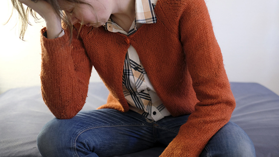 Barn lutar huvudet mot sin hand och verkar trött