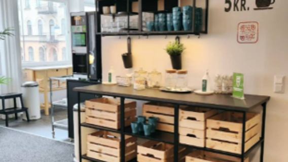 bild på trähyllor med glas och kaffekoppar och en bänk under med fika framdukat