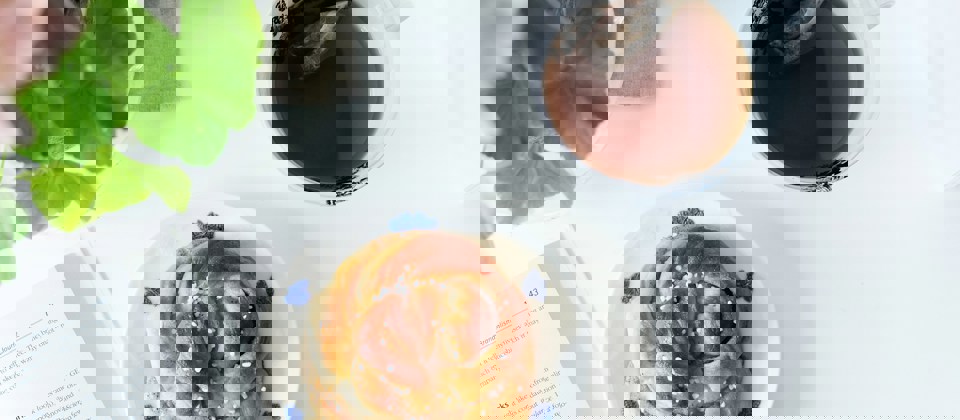 Ett barn och en vuxen i en simbassäng. Barnet har en flytboj runt sig.